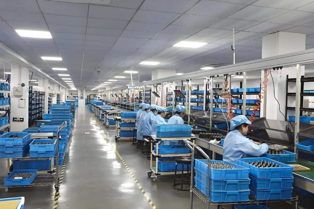 Workers assembling cleaning appliances in a modern factory.