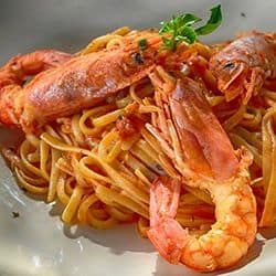 Close-up of shrimp and pasta dish with herbs on top.