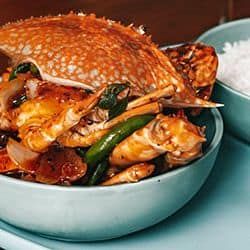 Delicious crab dish with vegetables served in a blue bowl.