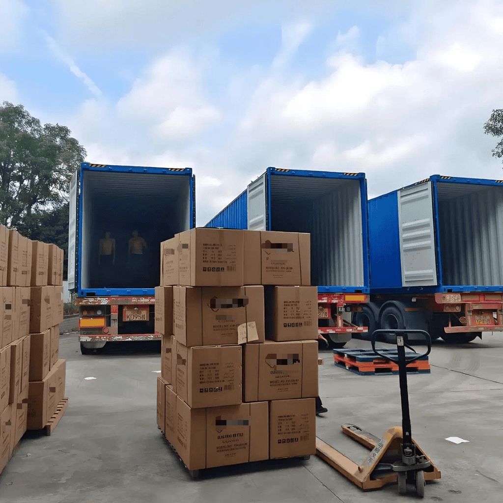 Loading and unloading of boxes at a logistics facility with trucks and pallet jacks.