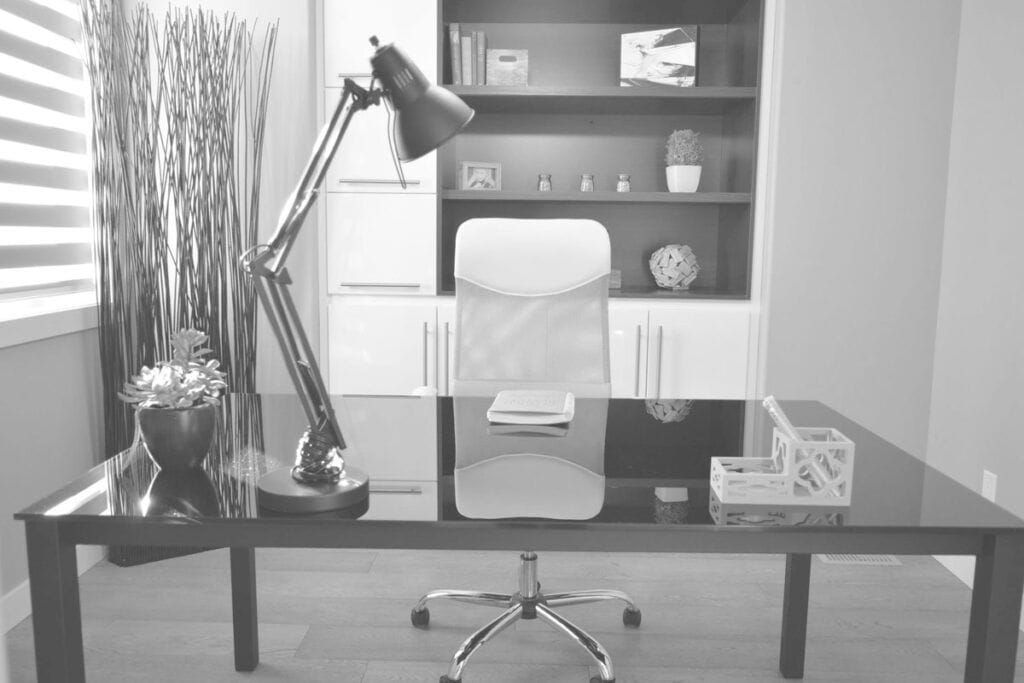 ABOUT US 3 Modern office desk with lamp, chair, and decorative items in a clean workspace.