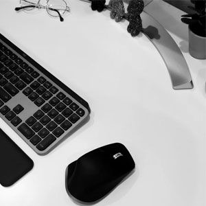Computer keyboard and mouse on a clean white desk for office work.