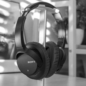 Sony wireless headphones on a stand in a modern setting.